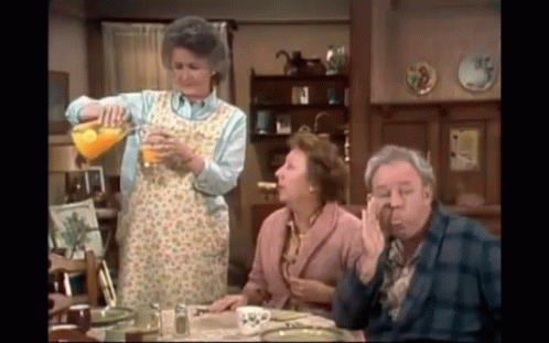 Woman Pouring Orange Juice Into Glass for Man and Two Women