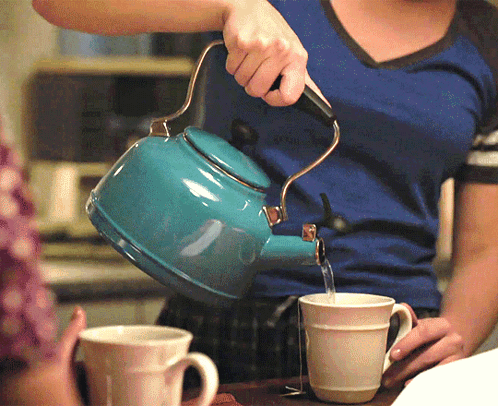 Woman Pouring Water from Blue Tea Kettle