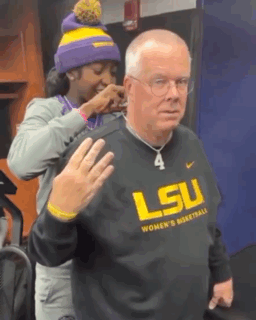 Woman Putting Necklace on Man in LSU Basketball Sweatshirt
