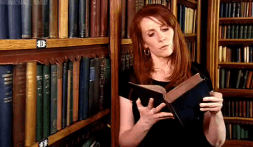 Woman Reading Book in Library