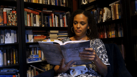 Woman Reading Book Inside Library GIF