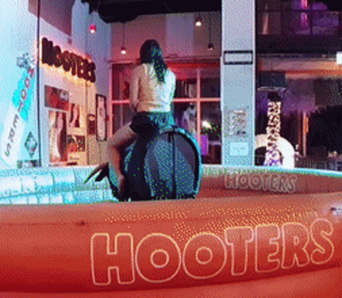 Woman Riding Rodeo Bull At Hooters Sign GIF
