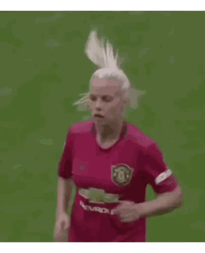 Woman Running on Soccer Field in Red Jersey