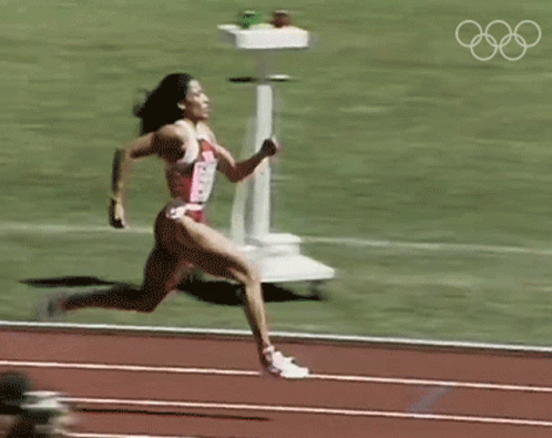Woman Running on Track With Olympic Rings
