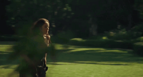 Woman Running Through Field of Greenery