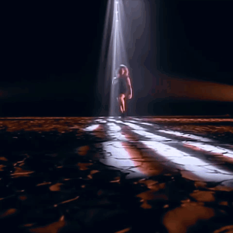 Woman's Legs In Black Boots On Wooden Floor GIF