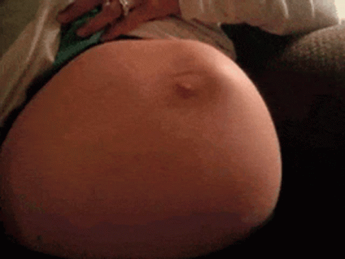 Woman's Pregnant Belly Waves As Baby Kicks GIF
