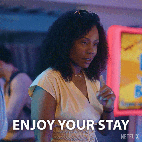 Woman Saying Enjoy Your Stay by Neon Sign