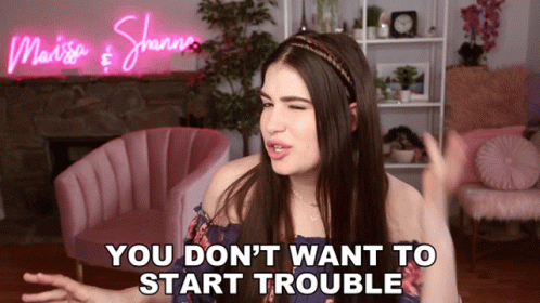 Woman Saying You Don't Want To Start Trouble In Front Of Pink Chair GIF
