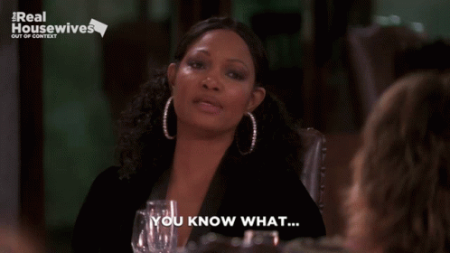 Woman Saying You Know What in Front of Real Housewives Sign