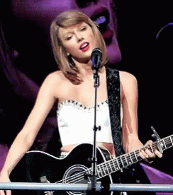Woman Singing Into Microphone and Guitar