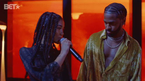 Woman Singing into Microphone and Man with BET Logo