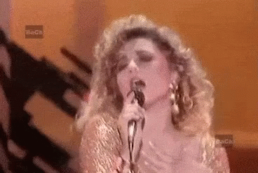 Woman Singing Into Microphone in Front of Beca Sign