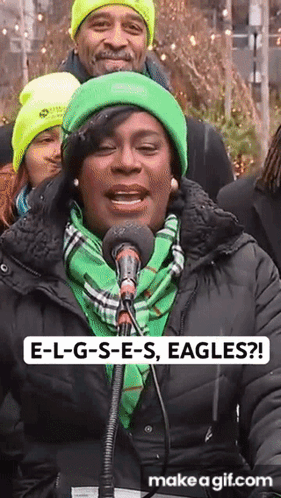 Woman Singing Into Microphone in Green Hat and Scarf
