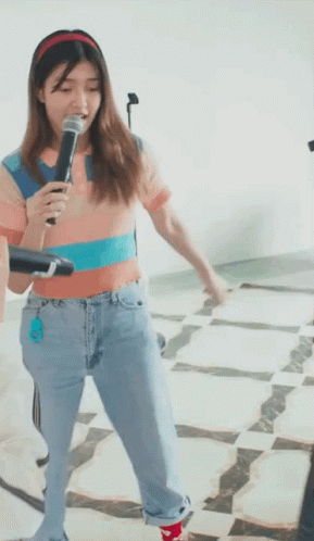 Woman Singing Into Microphone In Jeans And Headband GIF