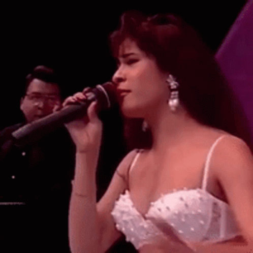 Woman Singing Into Microphone In White Dress And Earrings GIF