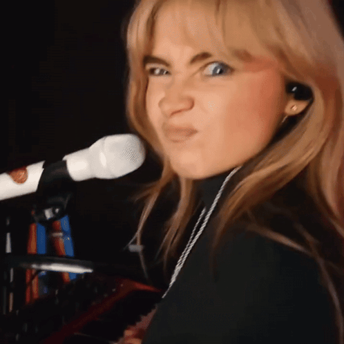 Woman Singing Into Microphone Making Face