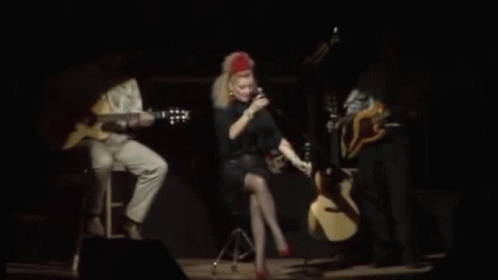 Woman Singing Into Microphone on Stage