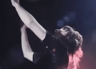Woman Singing Into Microphone On Stage Arms Outstretched GIF