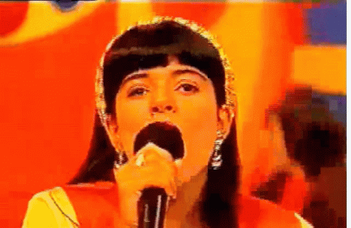 Woman Singing Into Microphone Orange Background