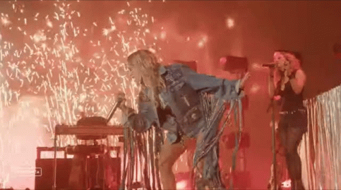 Woman Singing Into Microphone With Fireworks