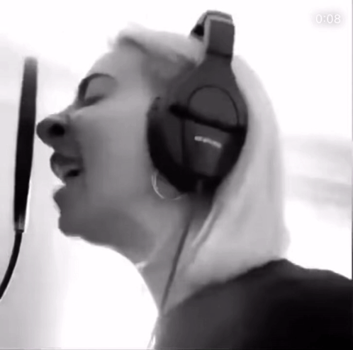 Woman Singing into Microphone with Headphones in Black and White