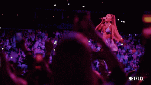 Woman Singing Into Microphone With Netflix Logo And Crowd GIF