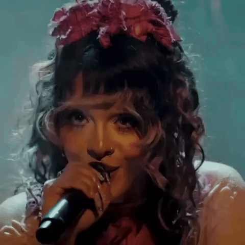 Woman Singing Into Microphone With Pink Flower