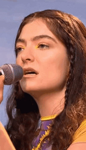 Woman Singing Into Microphone With Yellow Eyeshadow GIF