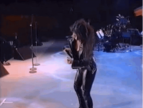 Woman Singing on Stage With Microphone