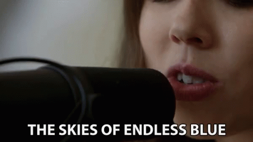 Woman Singing Skies of Endless Blue Into Microphone