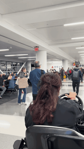 Woman Sitting at Airport With Delta Sign