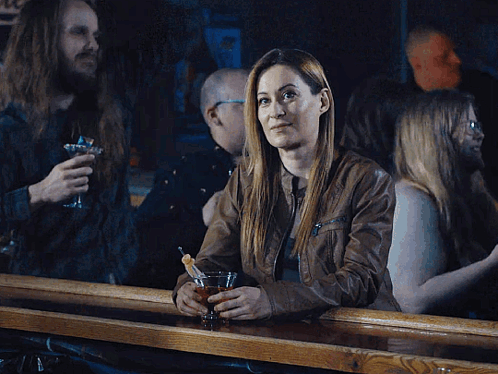 Woman Sitting at Bar Holding Drink