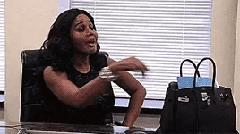 Woman Sitting at Desk With Arms Outstretched