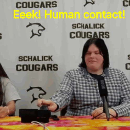 Woman Sitting at Microphone Sign Schalick Cougars
