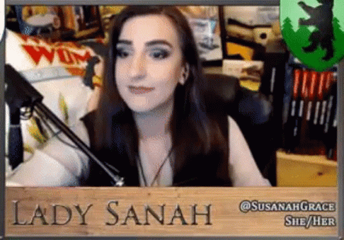 Woman Sitting At Microphone With Lady Sanah Sign GIF
