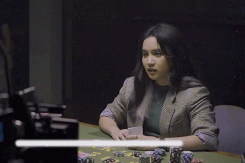 Woman Sitting at Poker Table Holding Card