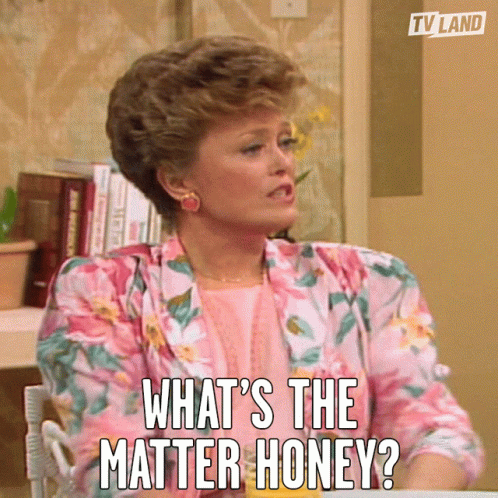 Woman Sitting at Table Asking 'What's the Matter Honey