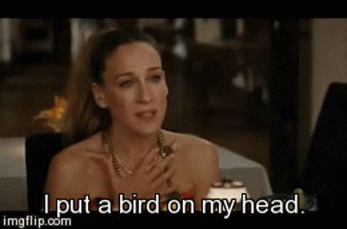 Woman Sitting at Table Saying I Put Bird on My Head