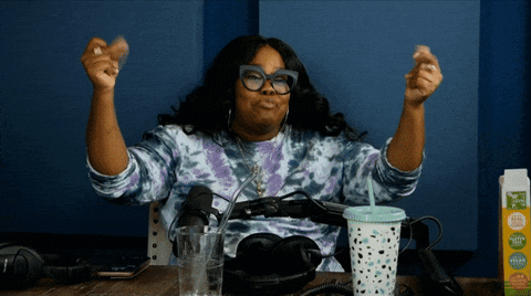 Woman Sitting At Table With Arms Up Next To Tropicana Carton GIF