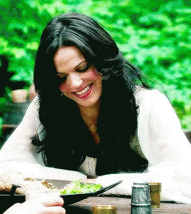 Woman Sitting at Table with Bowl of Food Smiling