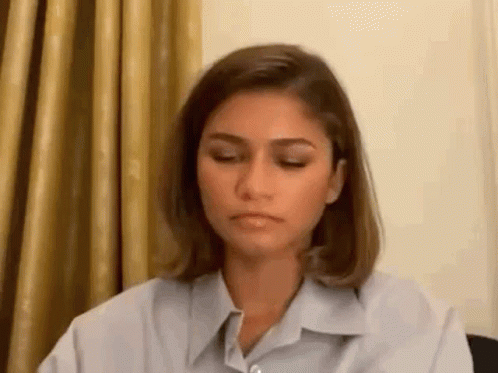 Woman Sitting At Table With Eyes Closed GIF