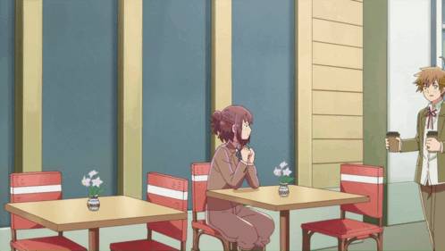 Woman Sitting At Table With Flowers In Vase GIF