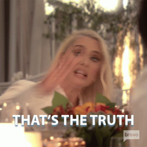 Woman Sitting At Table With Flowers Says That's The Truth GIF