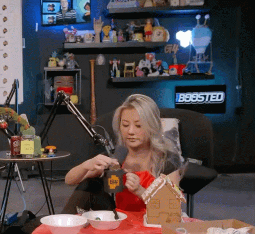 Woman Sitting At Table With Gingerbread House GIF