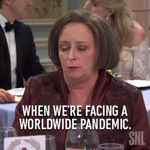 Woman Sitting at Table with Pandemic Sign