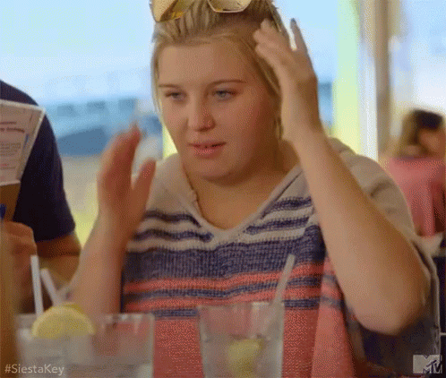 Woman Sitting At Table With Water And Lemon GIF
