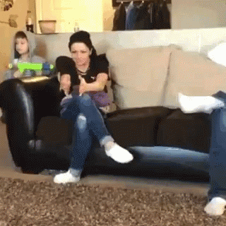 Woman Sitting Crossed Legs Child Holds Toy Gun GIF