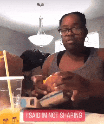 Woman Sitting Eating Hamburger Sign Saying Not Sharing