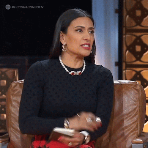 Woman Sitting in Black Sweater and Pearls